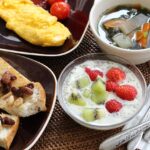 Colazione giapponese sana con riso, pesce, alghe e verdure per un metabolismo attivo.